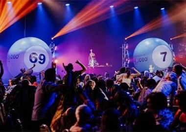 Podium van Bingo Loco in een feestruimte met lichtshow en publiek