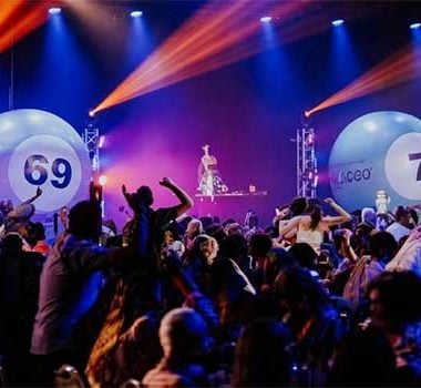 Podium van Bingo Loco in een feestruimte met lichtshow en publiek