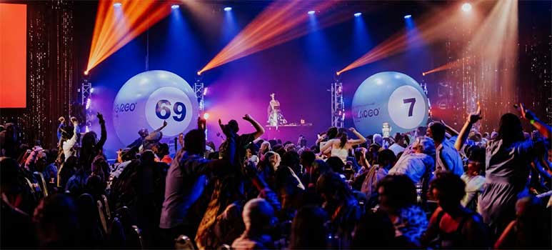 Podium van Bingo Loco in een feestruimte met lichtshow en publiek